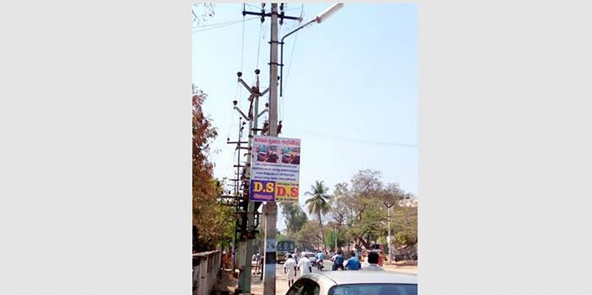 தெருவிளக்குகளில் கட்டப்பட்டுள்ள விளம்பர பதாகைகளை அகற்ற கோரிக்கை